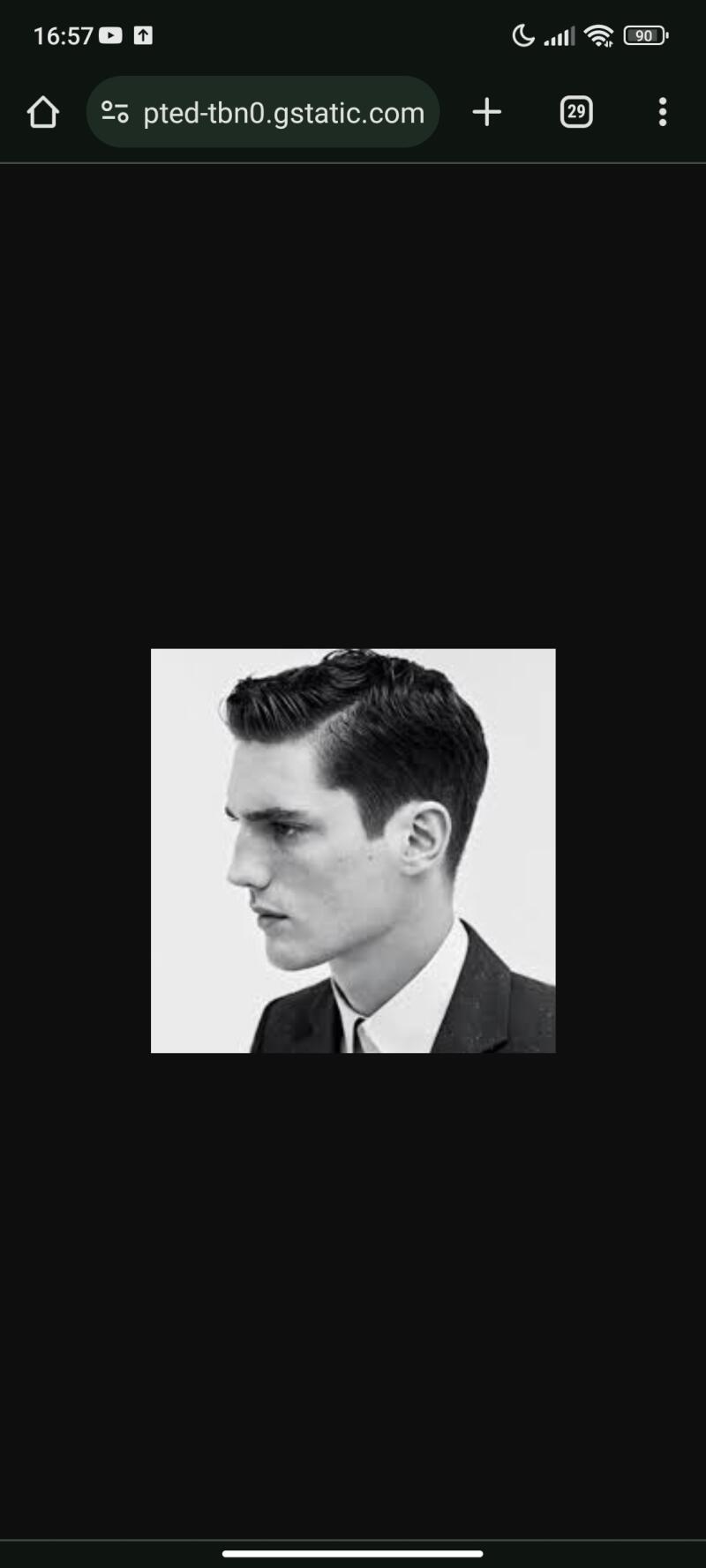 A black and white close-up of a man with a side part hairstyle wearing a suit and tie.