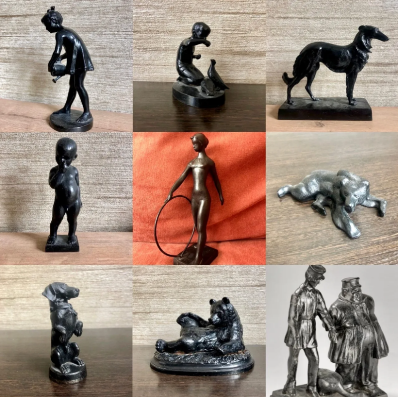 The image shows a collection of nine dark-colored figurines, including representations of children, animals like dogs and bears, and human figures in various poses and activities.