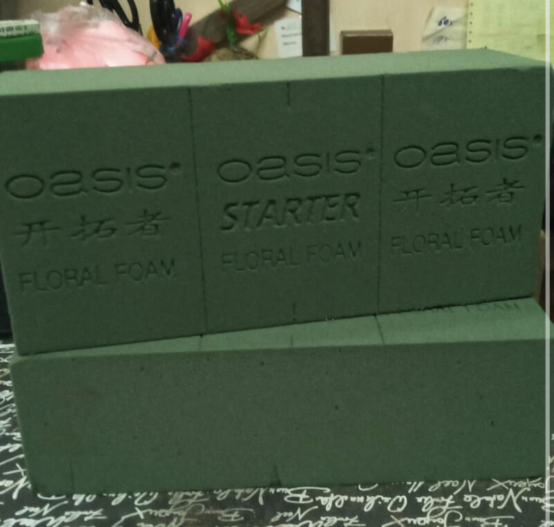 Two green blocks of 'Oasis' floral foam are stacked on top of each other, with text on the blocks that reads 'Oasis,' 'Starter,' 'Floral Foam,' and some Chinese characters.
