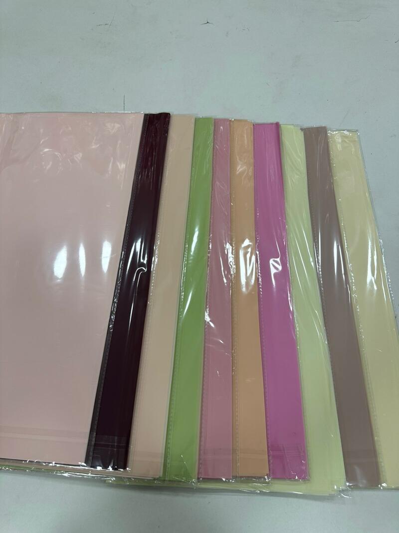 The image shows a row of colorful file folders, each a different pastel shade and individually wrapped in clear plastic.