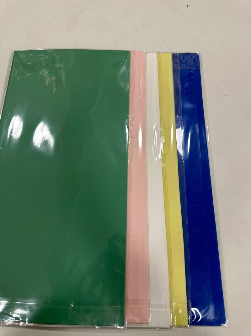The image displays a set of colorful plastic folders. The folders come in green, pink, white, yellow, and blue, and they are individually wrapped in clear plastic.