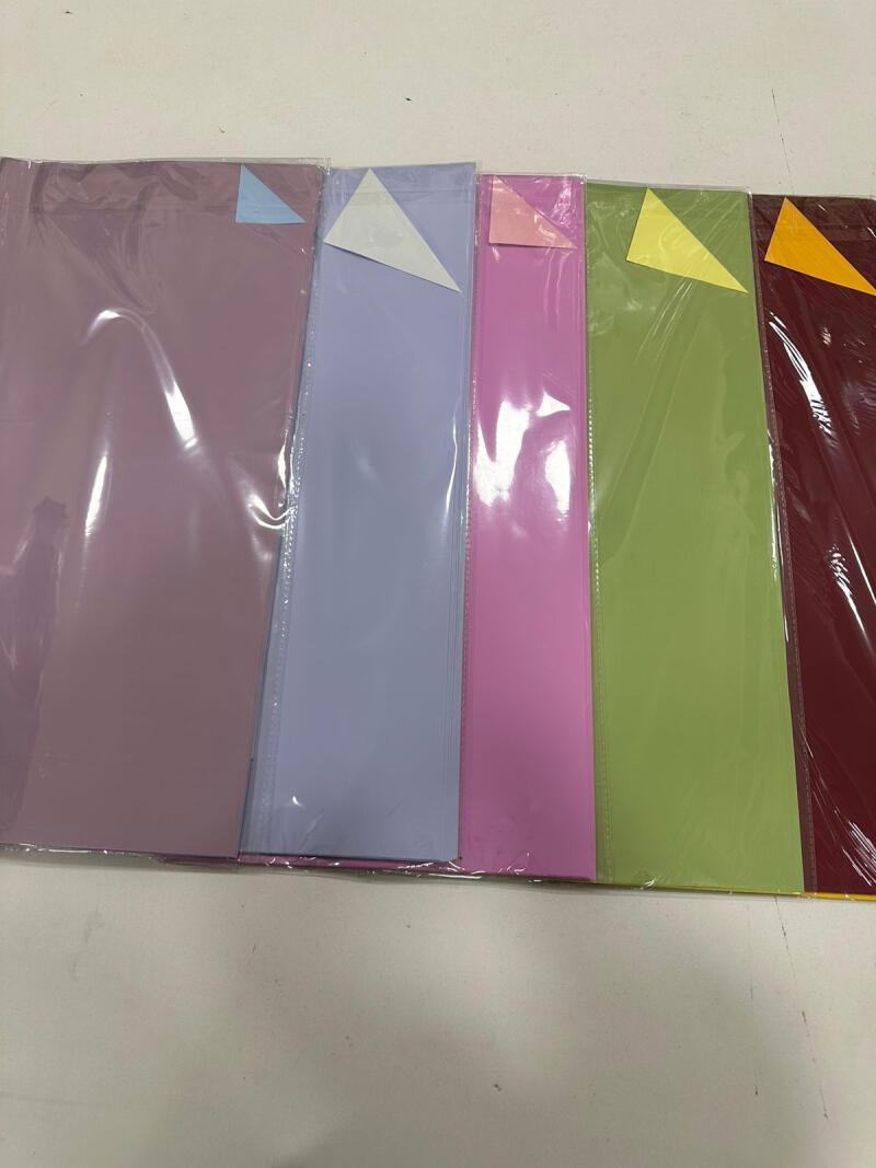 A set of colorful construction paper sheets are individually wrapped in plastic.