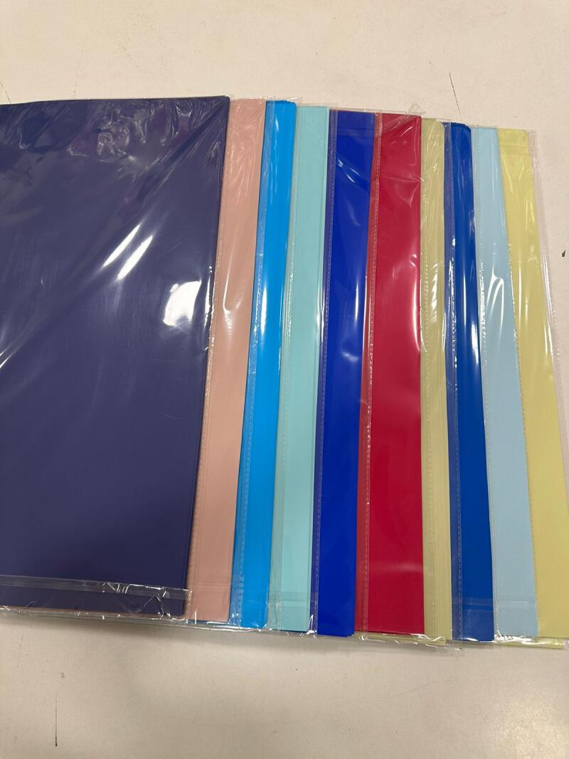 The image shows a row of colorful file folders in shades of blue, pink, red, and yellow, each individually wrapped in clear plastic.