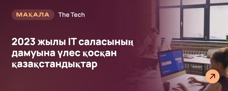 Баннер с текстом 'МАҚАЛА', 'The Tech' и '2023 жылы IT саласының дамуына үлес қосқан қазақстандықтар' на темном фоне, частично наложенный на размытую офисную сцену, где люди работают за компьютерами, включая женщину на переднем плане с ноутбуком, на котором отображается '85.00%'. Оранжевая круглая иконка со стрелкой находится в правом нижнем углу.