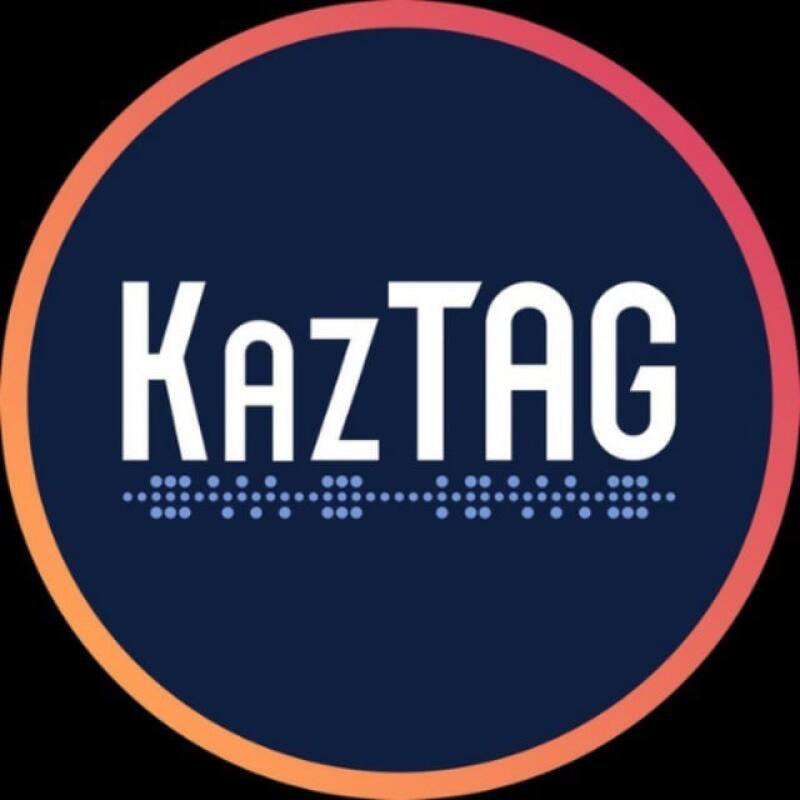 The image features a logo with the word "KazTAG" in white, uppercase letters. Below the word, there's a line of dots resembling Braille. The logo is set against a dark blue circle with an orange border.