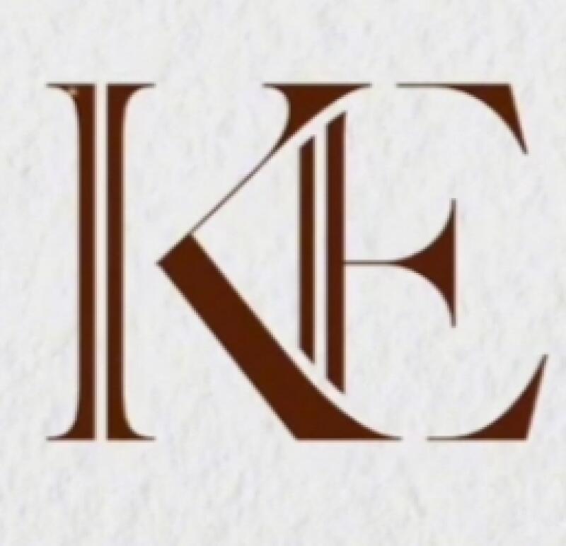 The image features a brown-colored monogram of the letters 'KE' in a stylized, interlocking design, set against a white textured background.