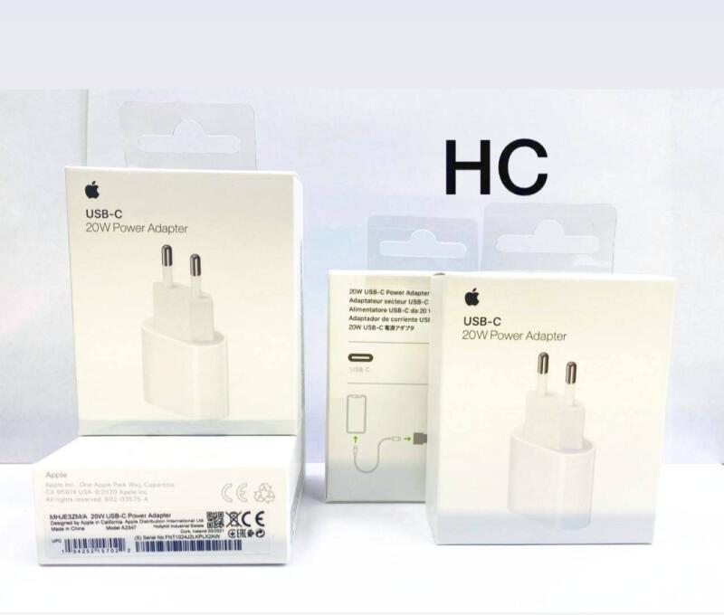 На изображении несколько коробок с адаптерами питания Apple 20W USB-C. На коробках изображен адаптер и текст, включающий "USB-C 20W Power Adapter" и другую нормативную информацию.