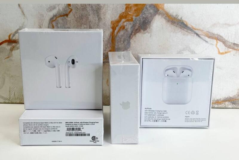 На изображении три неоткрытые белые коробки Apple AirPods, одна со стандартным зарядным чехлом, а другая с чехлом для беспроводной зарядки; виден текст на коробках.