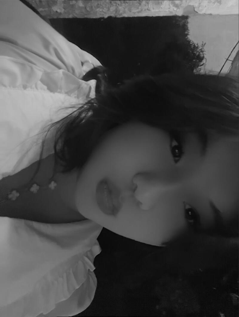 A black and white portrait of a woman with dark hair and light-colored clothing.