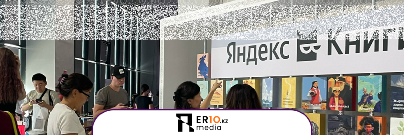 На изображении группа людей на книжной выставке с вывеской «Яндекс Книги» и различными обложками книг.