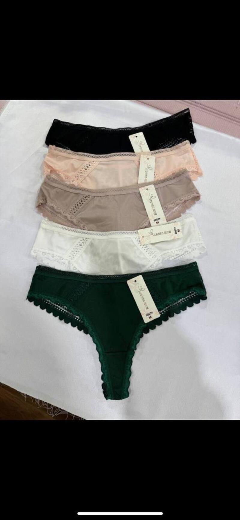 Five pairs of women's underwear in black, peach, taupe, white, and green are stacked on top of each other with tags attached.
