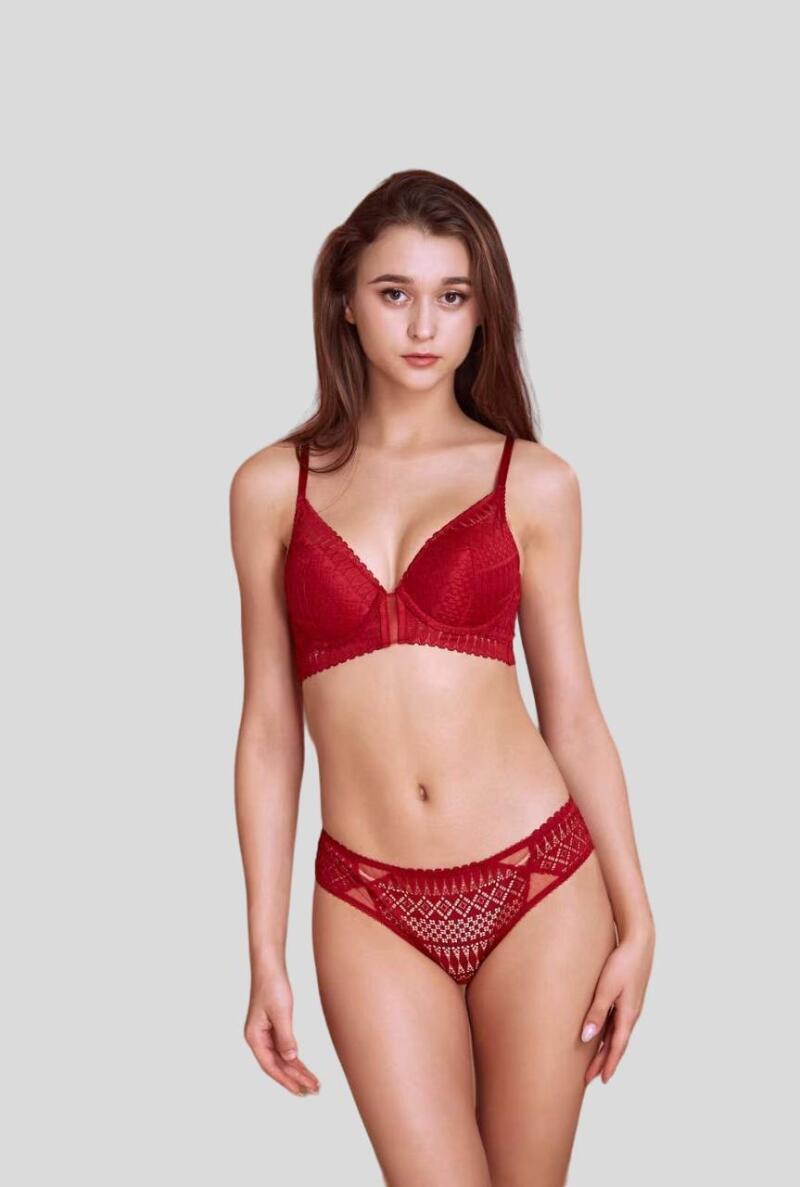 A woman is wearing a matching red lace bra and panty set.