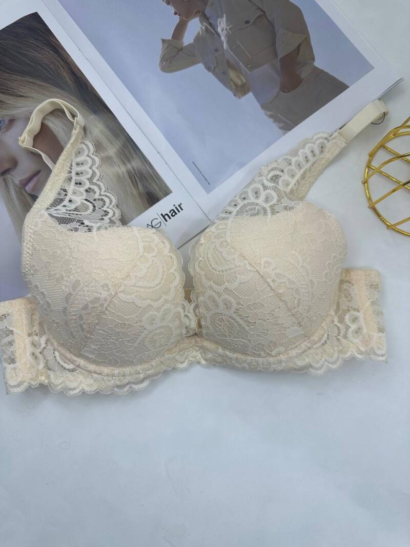 A beige lace bra is displayed on a white surface with a magazine in the background that reads "hair".