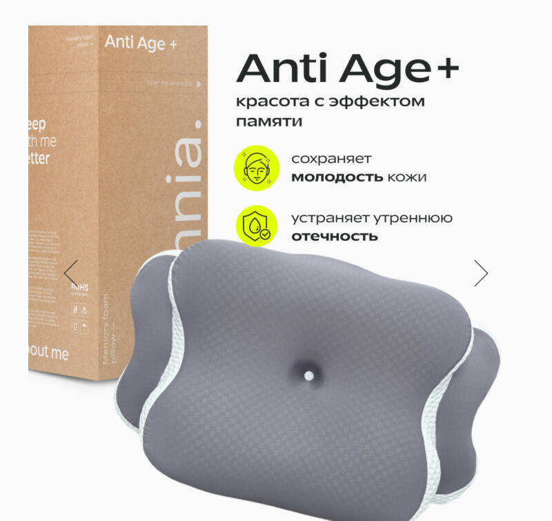 The image shows a gray memory foam pillow with white trim, accompanied by text in Russian promoting the pillow's anti-aging benefits, including maintaining skin youthfulness and eliminating morning puffiness. The pillow is branded as 'Anti Age+'.