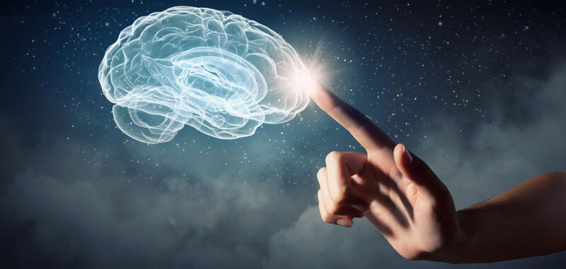 A glowing, transparent outline of a human brain is touched by a finger against a dark, starry background.