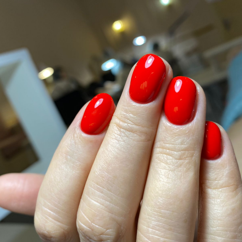 A close-up of a hand with red polished nails.