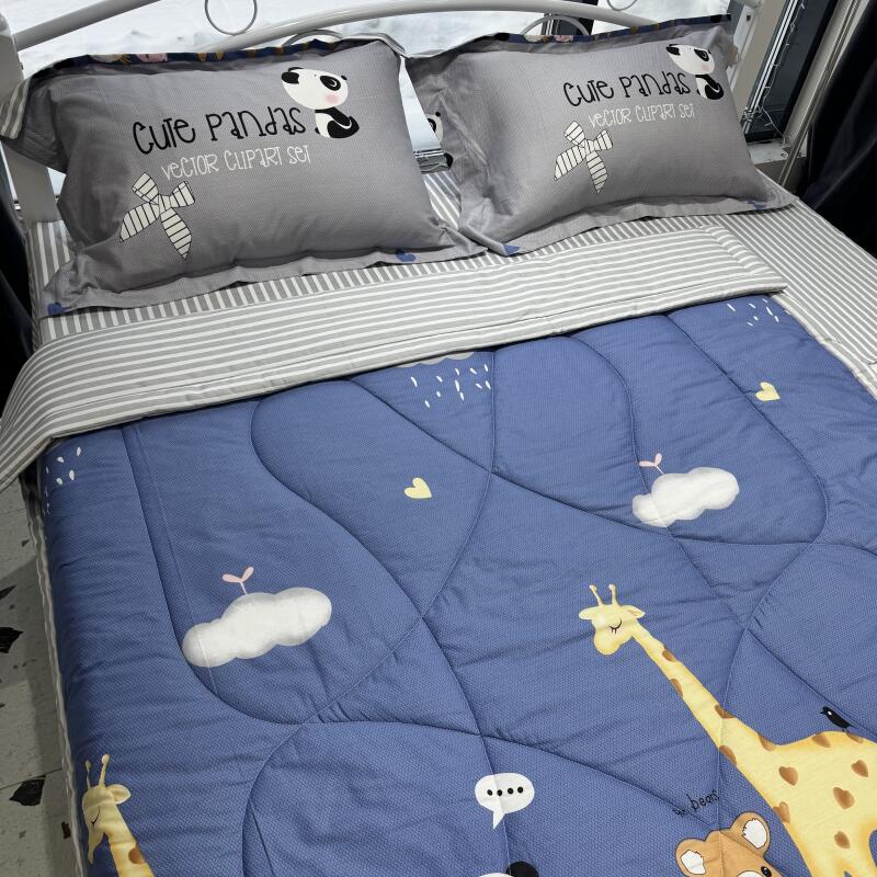 The image shows a bed with a blue comforter and two gray pillows with a panda design. The comforter features cartoon-like illustrations of clouds, hearts, giraffes, and bears, while the pillows read "Cute Pandas Vector Clipart Set."
