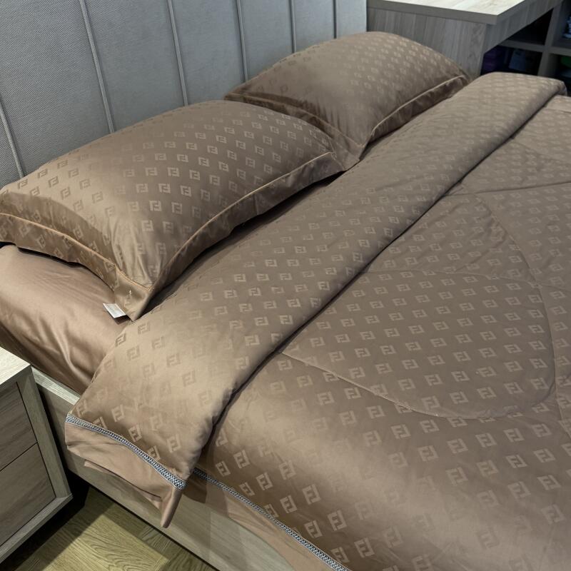 A bed is neatly made with brown patterned bedding, including two pillows and a comforter, all featuring a repeating 'F' logo pattern.