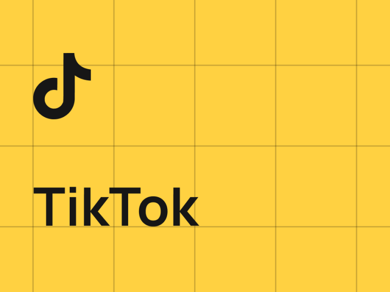 The image features the TikTok logo and text on a yellow grid background. The logo is a stylized musical note, and the text reads 'TikTok' in a simple font.