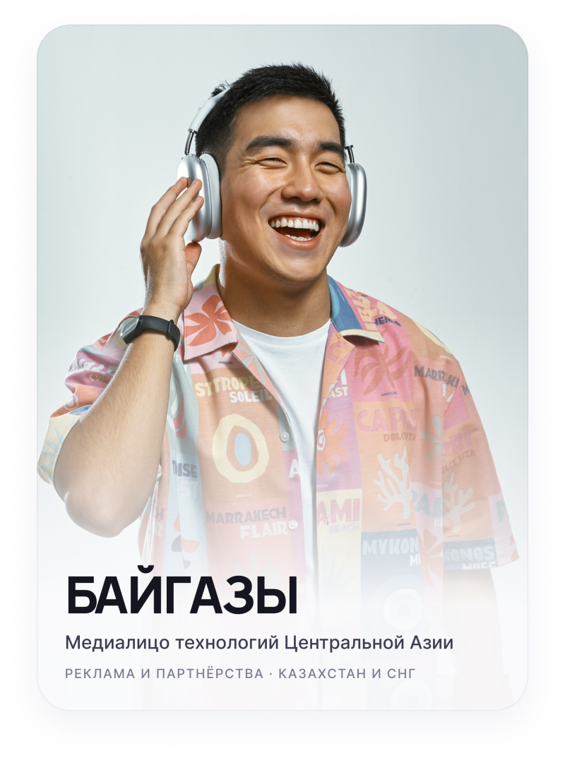 A joyful man with closed eyes, wearing silver headphones and a colorful patterned shirt, smiles broadly while touching his left headphone. Text at the bottom reads: "БАЙГАЗЫ", "Media face of Central Asian technologies", "ADVERTISING AND PARTNERSHIPS · KAZAKHSTAN AND CIS".