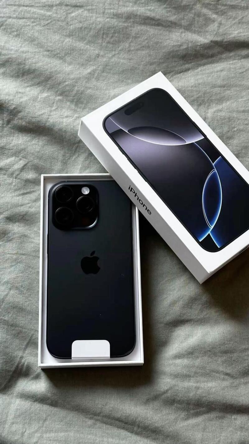 The image shows a black iPhone in its box, and the iPhone box is next to it on a gray surface. The box has the word "iPhone" printed on its side.