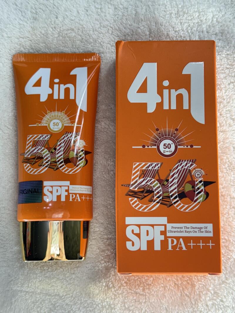 An orange tube and box of 4in1 50 SPF PA+++ sunscreen are displayed on a white surface.