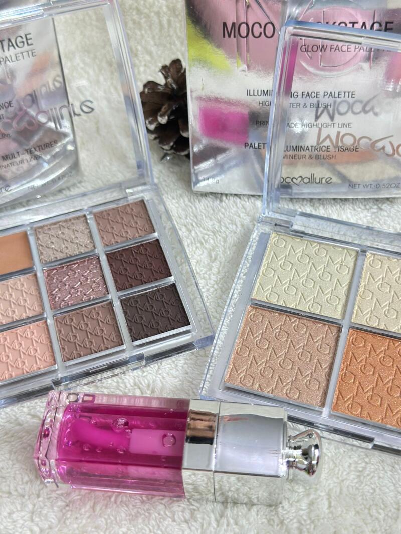 The image shows two open eyeshadow palettes with a range of neutral and warm tones, alongside a pink lip gloss and makeup boxes; the text on the palette includes 'TAGE PALETTE' and 'GLOW FACE PALETTE'.
