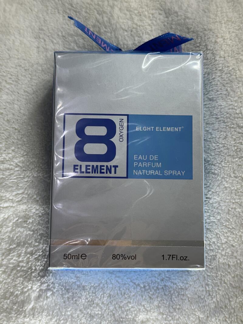 A box of Eight Element Eau de Parfum Natural Spray with a blue ribbon on top, showing the text '8 Oxygen Element', 'Eight Element', 'Eau de Parfum Natural Spray', '50ml e', '80% vol', and '1.7 Fl.oz.'