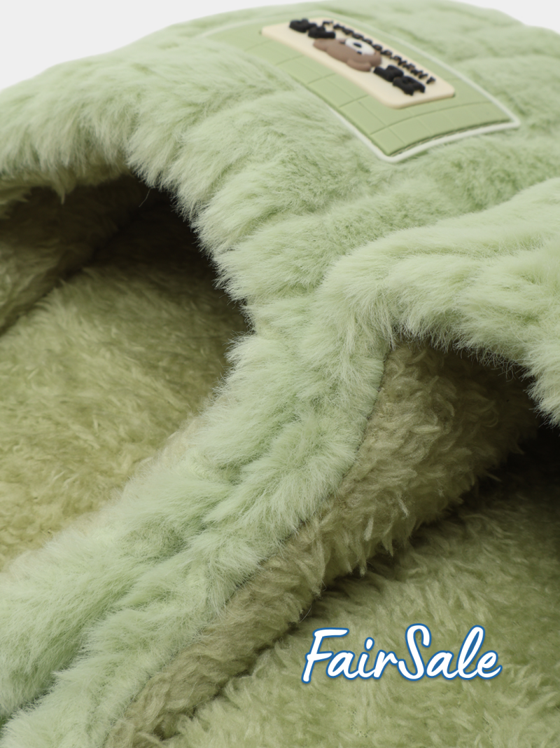 Close-up of a light green, furry pet bed with a rectangular label featuring a cartoon dog.