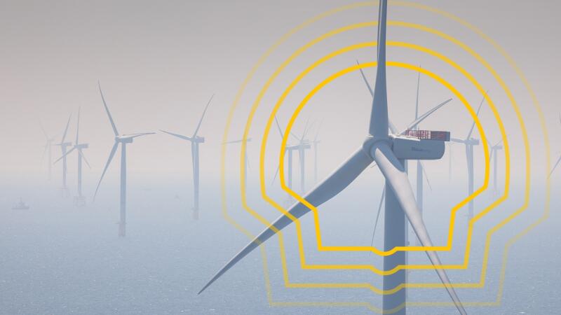 The photo shows a wind farm with multiple turbines, some of which are partially obscured by fog, with a yellow graphic overlay.