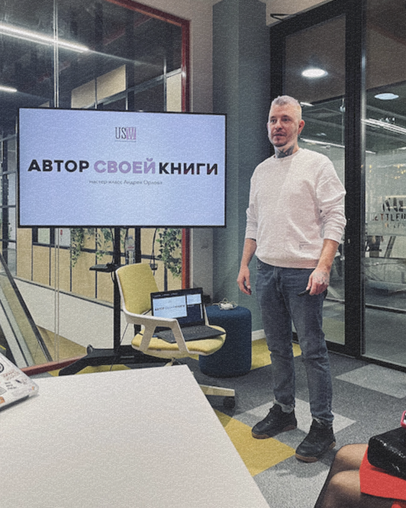 Мужчина стоит перед экраном с текстом 'Автор своей книги' и логотипом USW. Рядом на стуле стоит ноутбук.
