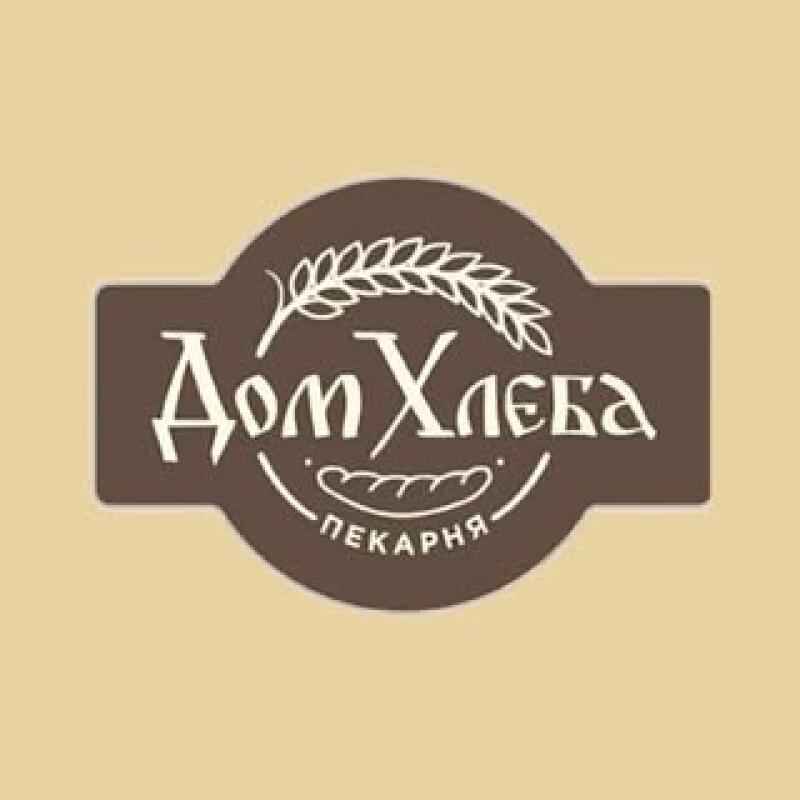 The image features a logo on a beige background, showcasing a brown emblem with the text "Дом Хлеба ПЕКАРНЯ" in white, adorned with a wheat stalk above and a stylized depiction of bread below.