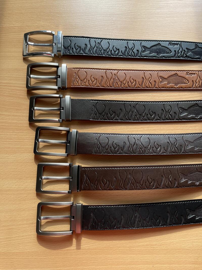 Six belts of different colors are lying on a wooden surface, each featuring a fish and seaweed pattern, and a buckle.