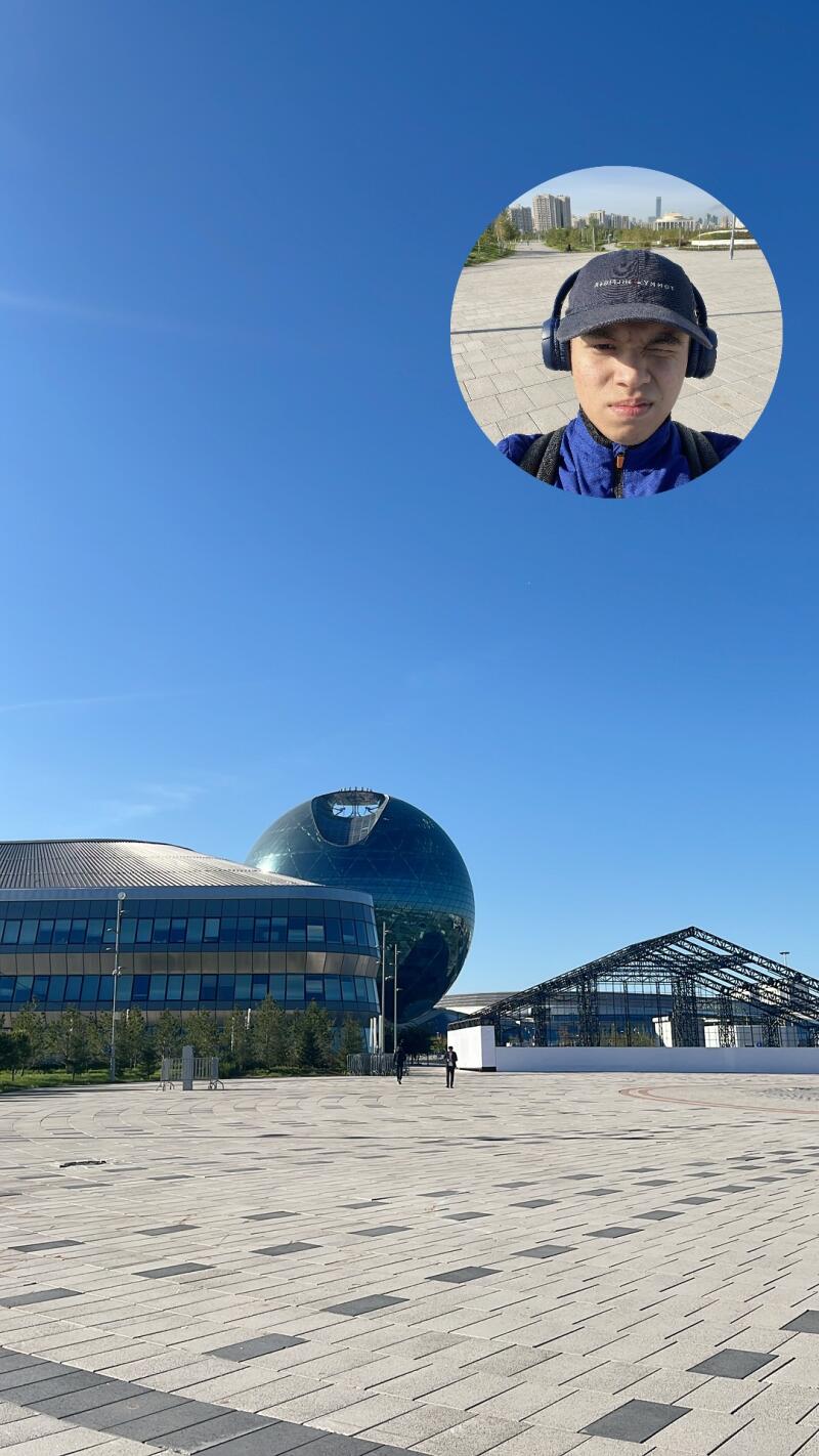 The photo features a man wearing a Tommy Hilfiger cap and headphones, winking in a circular inset at the top, with a cityscape that includes the Nur Alem sphere in the background.
