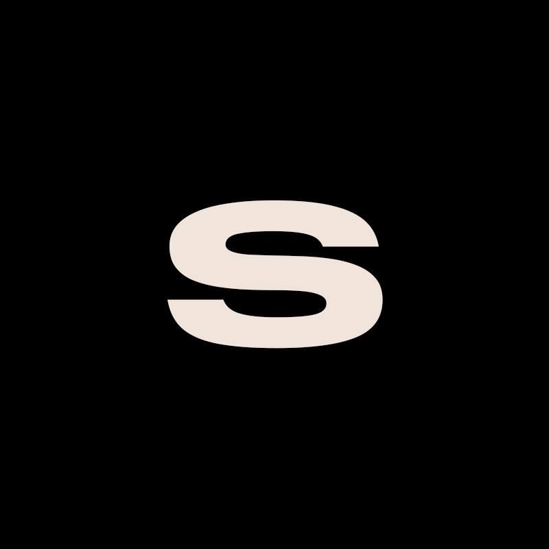 The image features a beige letter 'S' against a black background.
