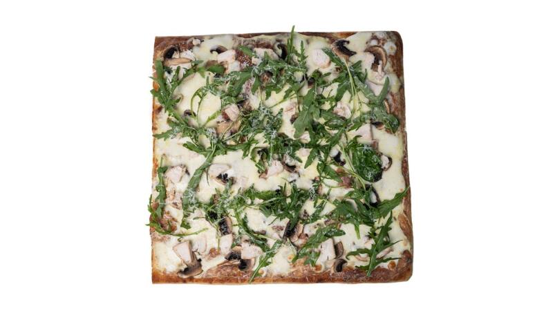 Квадратная пицца покрыта белым сыром, грибами и рукколой.