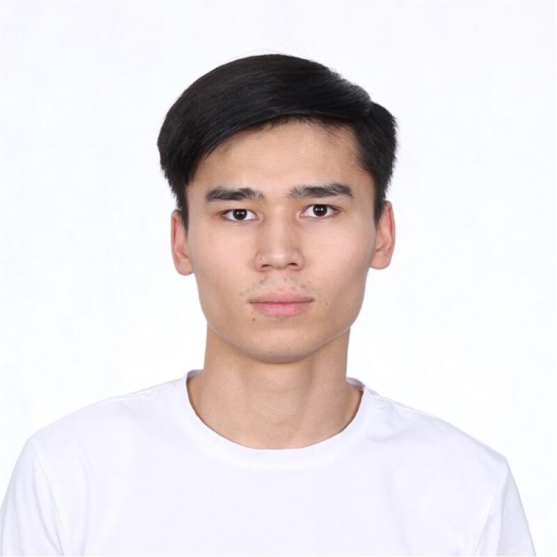 A portrait of a young man with dark hair and a white t-shirt against a white background.