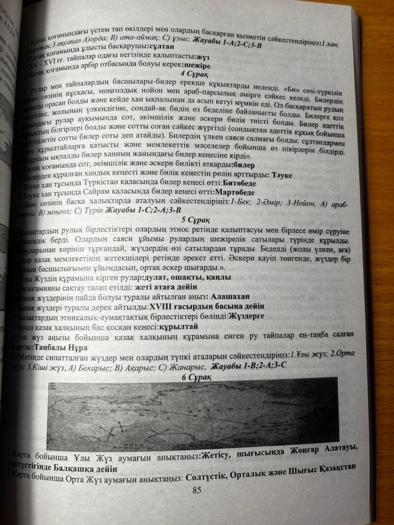 На открытой странице книги виден казахский текст и карта внизу, включая вопросы, касающиеся регионов и исторических аспектов казахских племен.