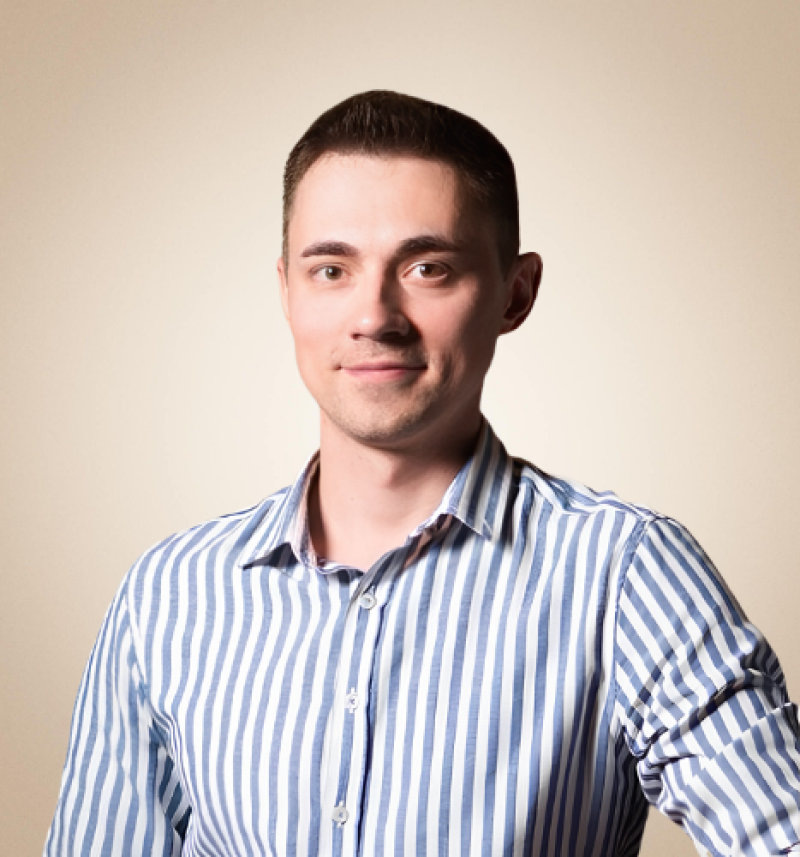 A man with short dark hair is wearing a blue and white striped shirt.
