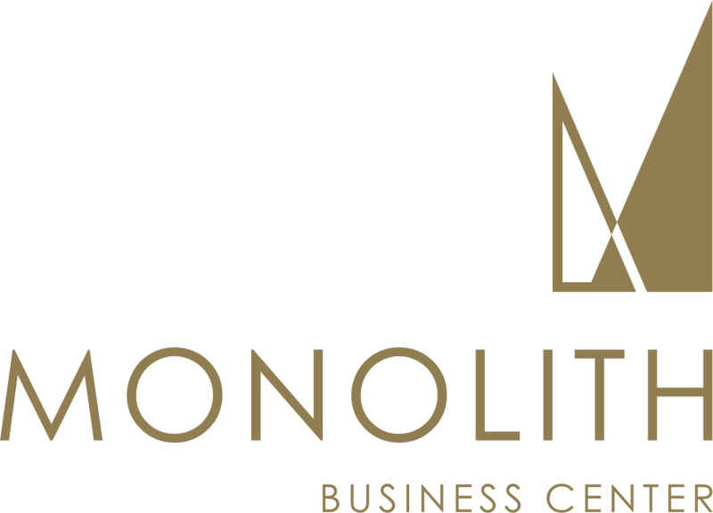 The logo for Monolith Business Center features a gold, abstract, geometric design above the text "MONOLITH BUSINESS CENTER" in a gold sans-serif font against a black background.