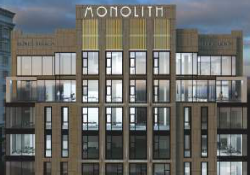 The image shows a tall building with many windows and the word "MONOLITH" at the top.