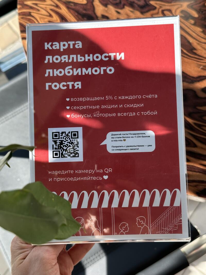 A red sign advertises a loyalty program, highlighting benefits such as 5% cashback on every bill, secret promotions and discounts, and bonuses. It includes a QR code for joining.