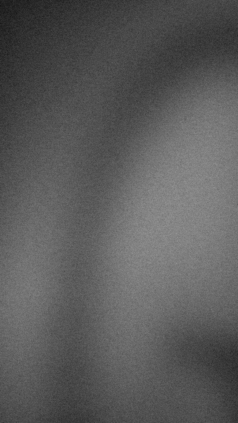 The image is a grainy, grayscale gradient, with darker areas in the corners and lighter areas in the center.