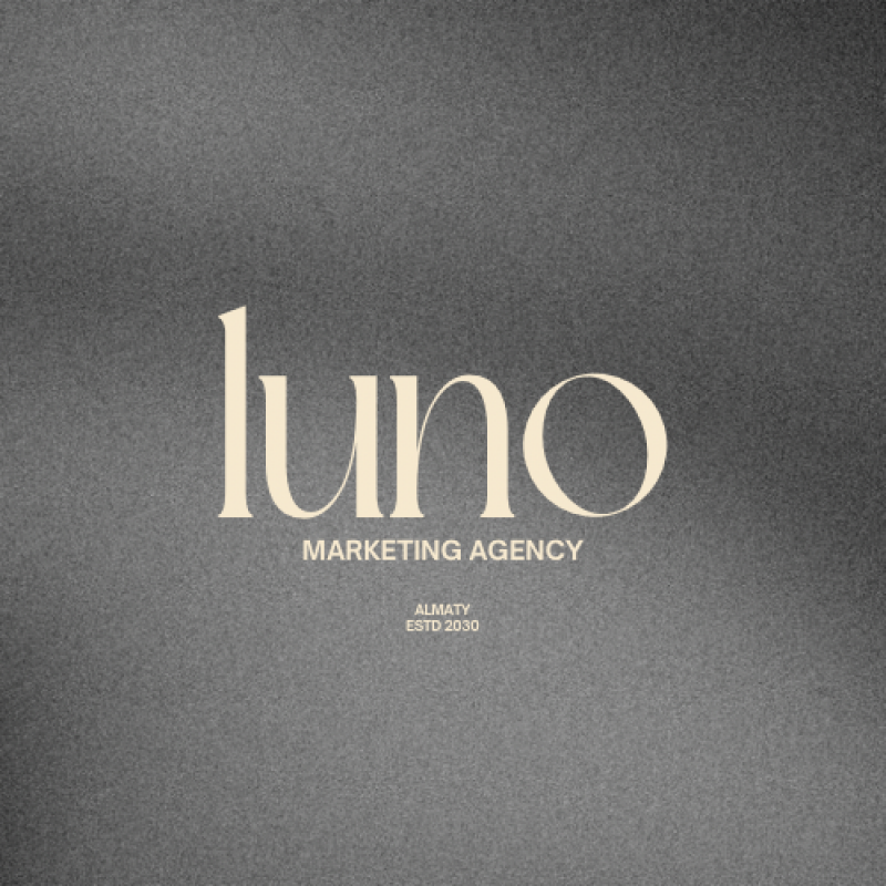 The image displays the word "luno" in a stylish, serif font, followed by the text "MARKETING AGENCY" in smaller, sans-serif letters and "ALMATY ESTD 2030" below; the background is a dark grey, textured surface.