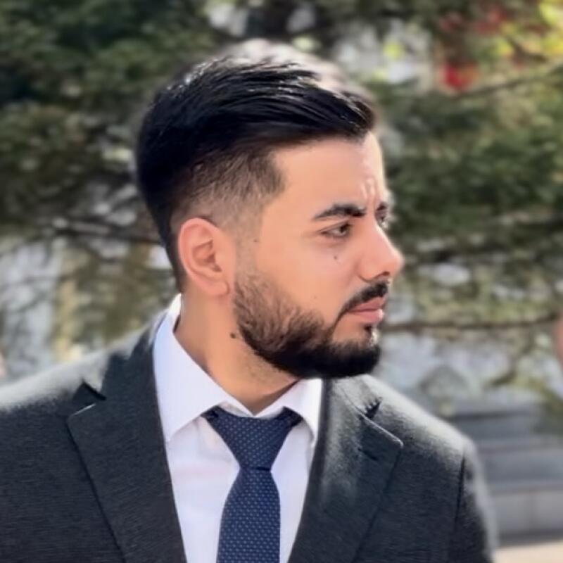 A man with a beard is wearing a suit and tie.