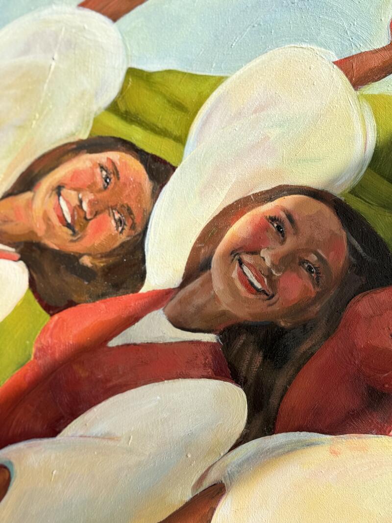 На картине изображены две улыбающиеся женщины в красно-белых топах, окруженные тем, что кажется белыми цветочными лепестками на зеленом и голубом фоне.