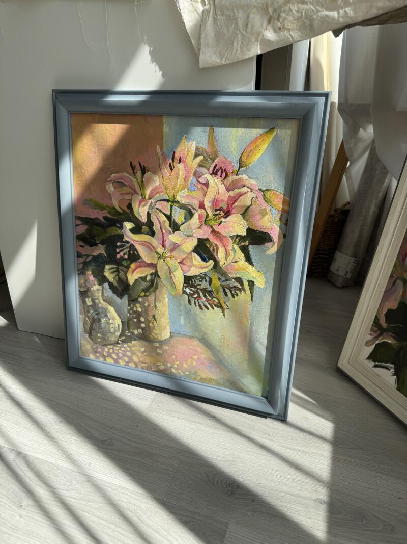 Картина маслом с изображением лилий в вазах обрамлена в синюю раму.