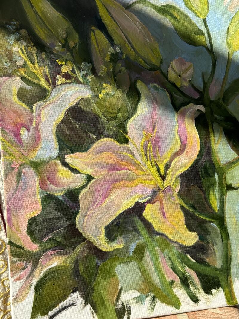Крупный план масляной живописи показывает светло-розовые и желтые лилии с зелеными стеблями и листвой на фоне мягко окрашенного фона.