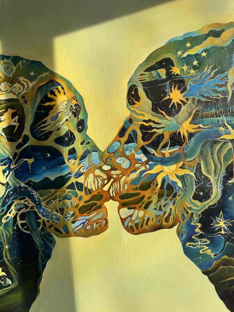 На картине изображены два лица в профиль, почти соприкасающиеся, на жёлтом фоне, а лица заполнены сюрреалистичными, космическими деталями, такими как звёзды, облака и небесные тела.