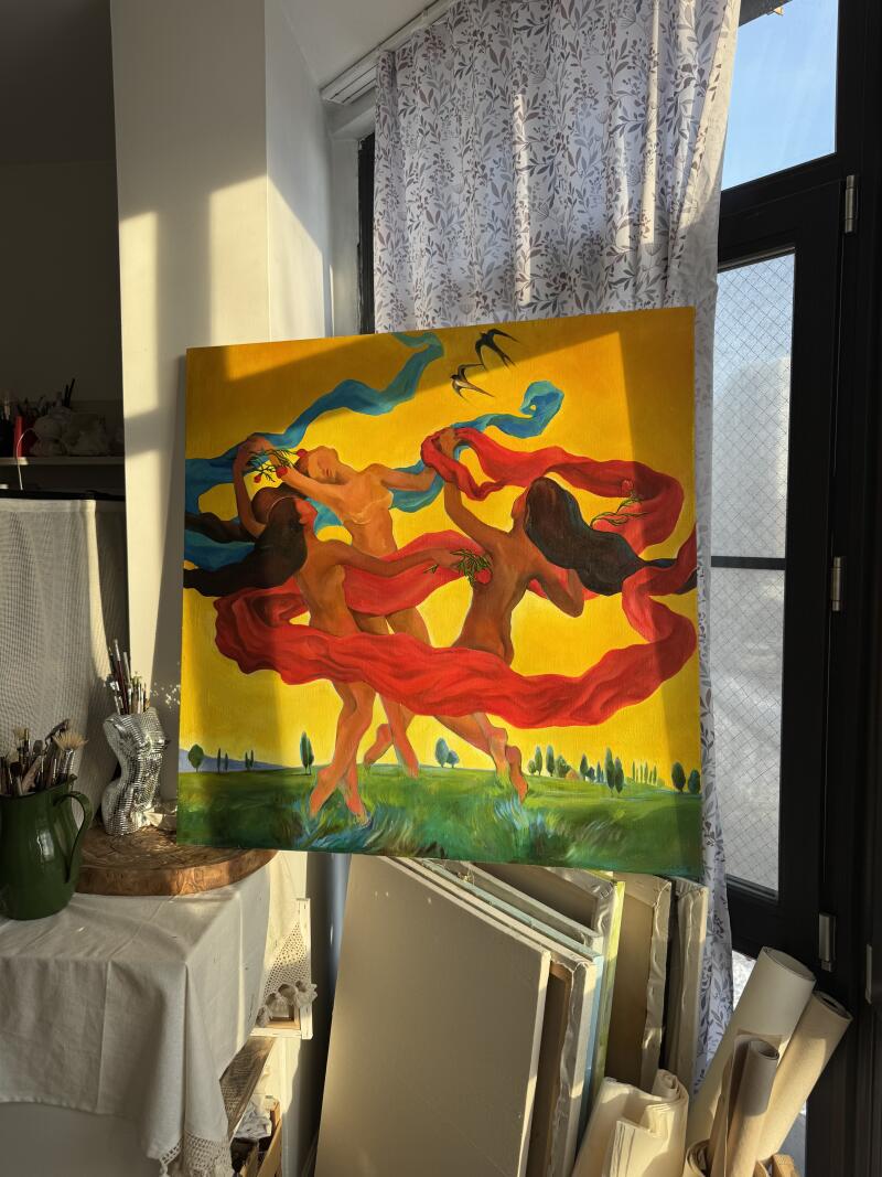 На изображении картина, изображающая трех обнаженных женщин, танцующих в поле, с синими и красными лентами, развевающимися вокруг них, на фоне желтого неба с силуэтами птиц.